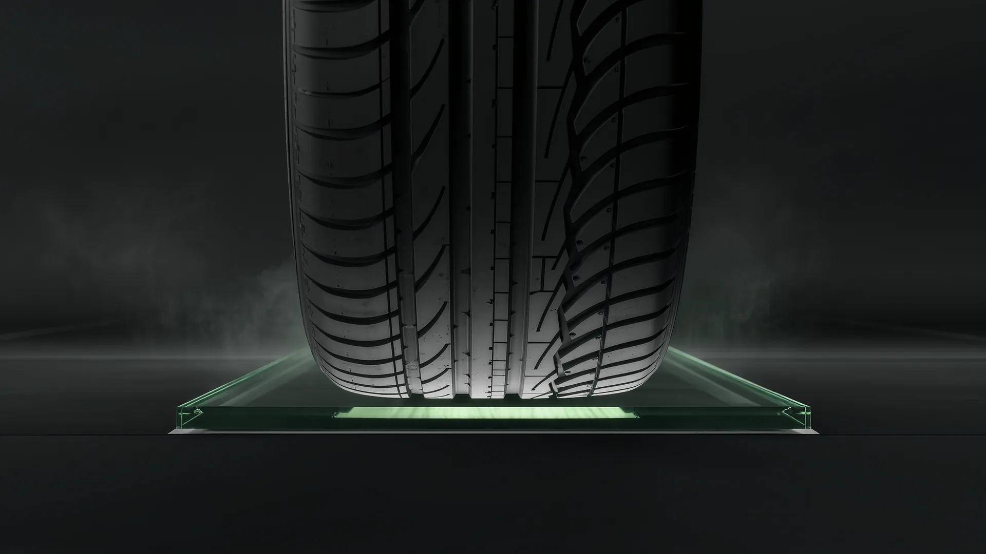 Underside view of a wide performance tyre showing its contact patch on glass
