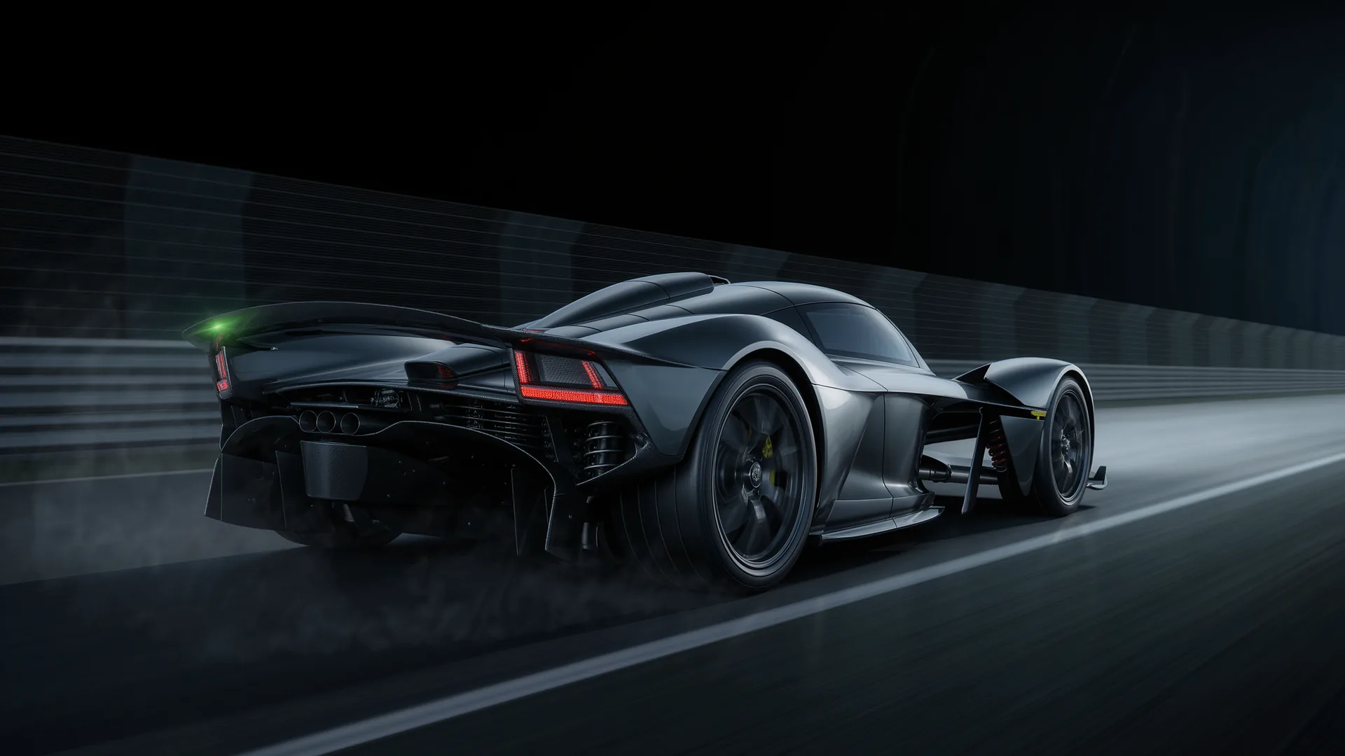 Performance car accelerating hard along an empty test track from a rolling start