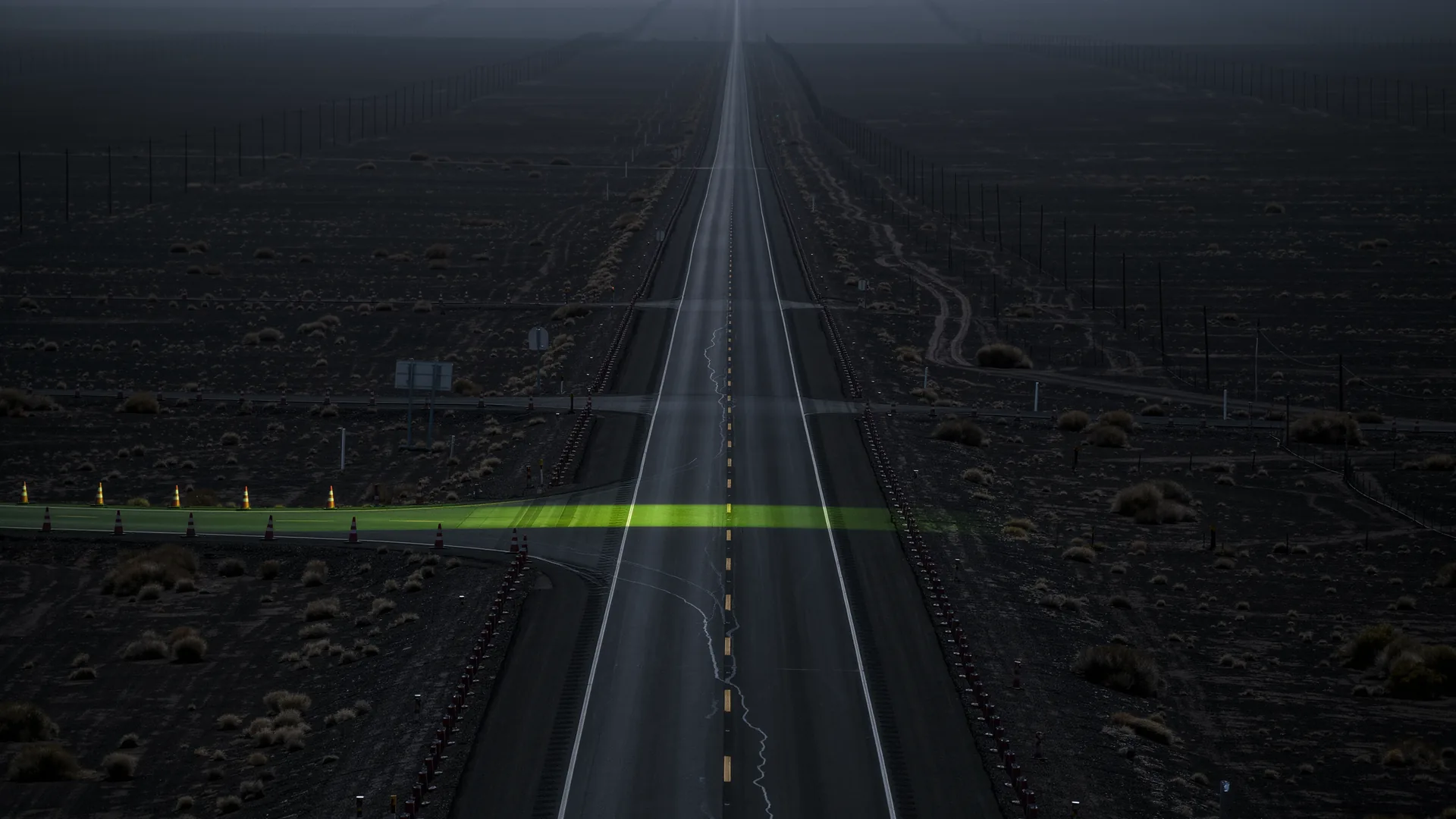 Long straight closed public road stretching to the horizon under a clear sky